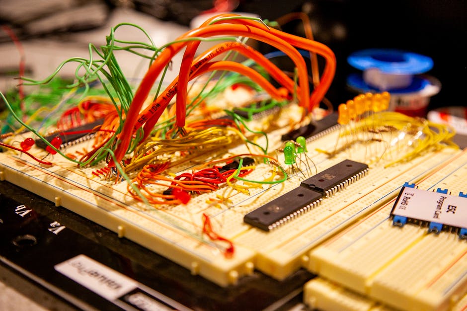 Vibrant breadboard with multicolored wires and electronic components in a detailed close-up.