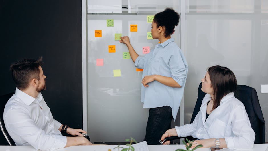Business team collaborating and brainstorming in a meeting room with sticky notes.